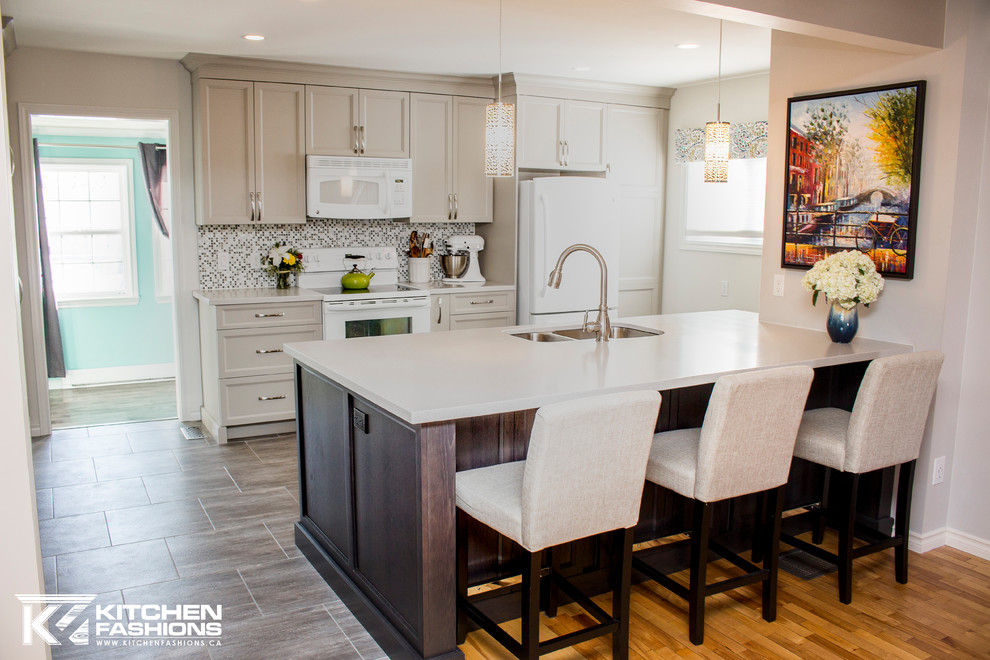 Example of a mid-sized transitional single-wall ceramic tile open concept kitchen design with an undermount sink, shaker cabinets, gray cabinets, solid surface countertops, gray backsplash, mosaic tile backsplash, white appliances and an island