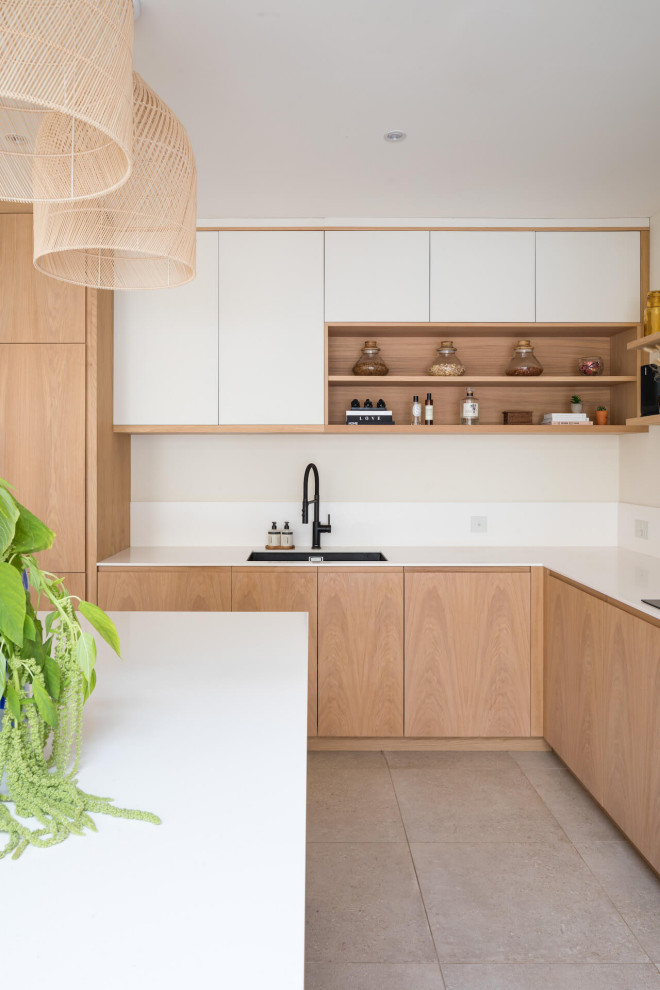 Photo of a mid-sized scandinavian kitchen in London with medium wood cabinets, with island and white benchtop.