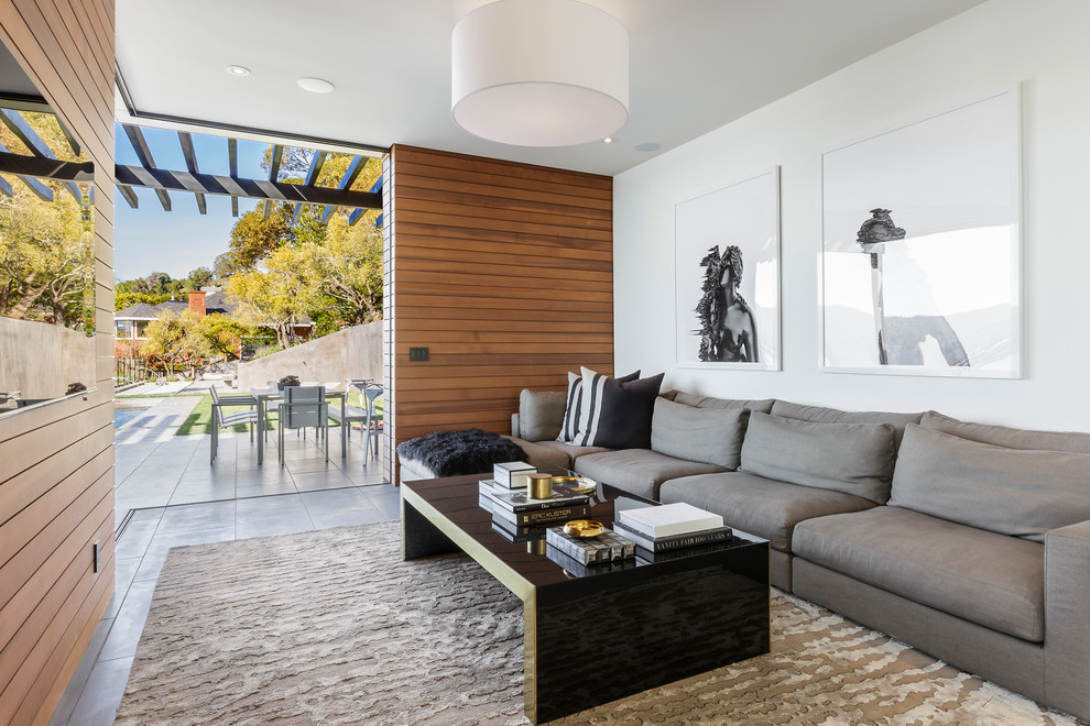 Mid-sized contemporary open concept family room in San Francisco with concrete floors, grey floor, white walls and a wall-mounted tv.