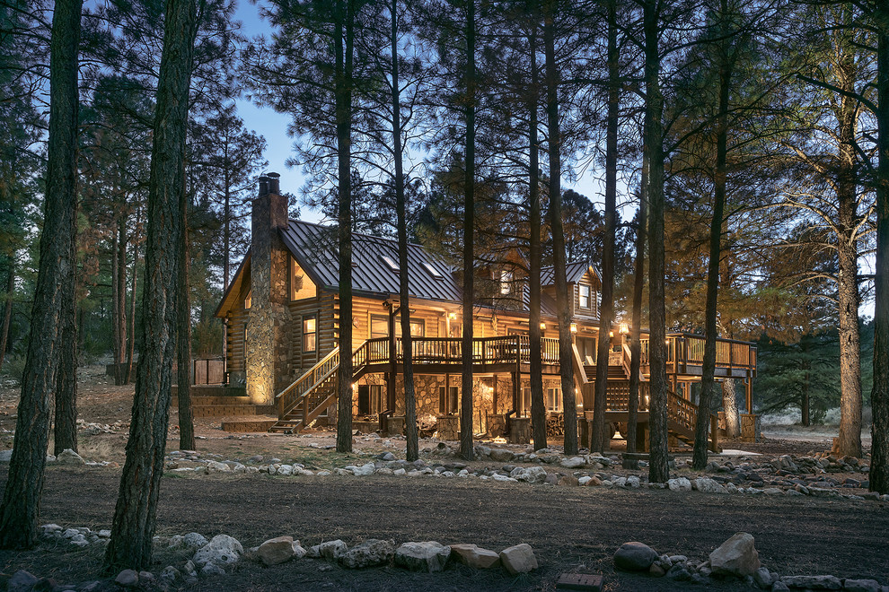 This is an example of a large country three-storey beige exterior in Phoenix with wood siding and a gable roof.