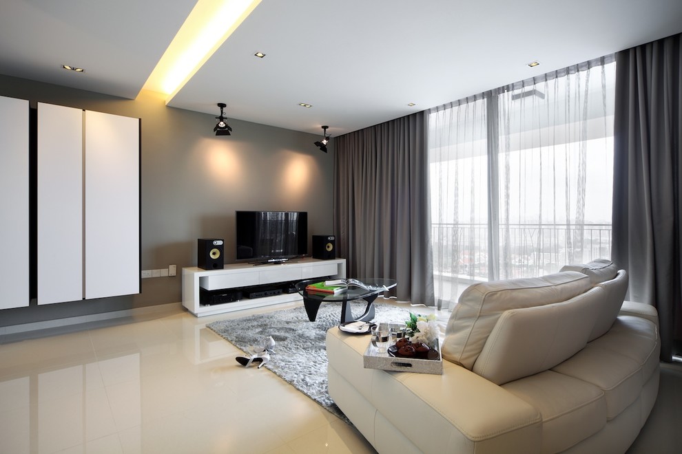Photo of a contemporary family room in Singapore with a freestanding tv, grey walls and beige floor.