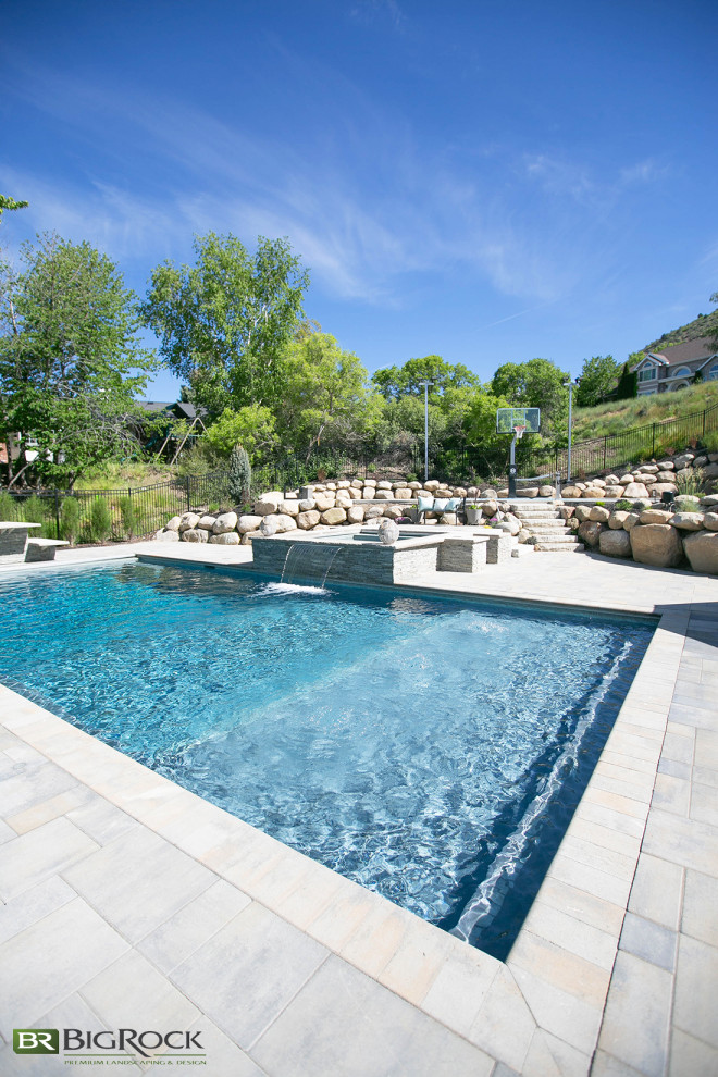 Contemporary back rectangular swimming pool in Salt Lake City with with pool landscaping and natural stone paving.