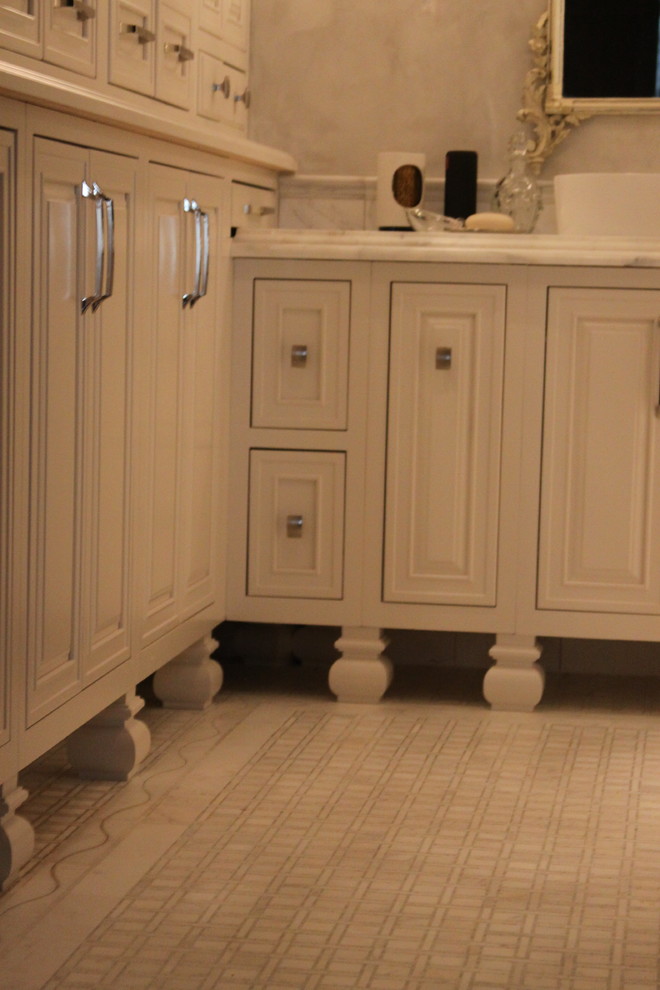 Inspiration for a mid-sized transitional master multicolored tile and stone tile marble floor freestanding bathtub remodel in Atlanta with a vessel sink, beaded inset cabinets, beige cabinets, marble countertops, a one-piece toilet and gray walls