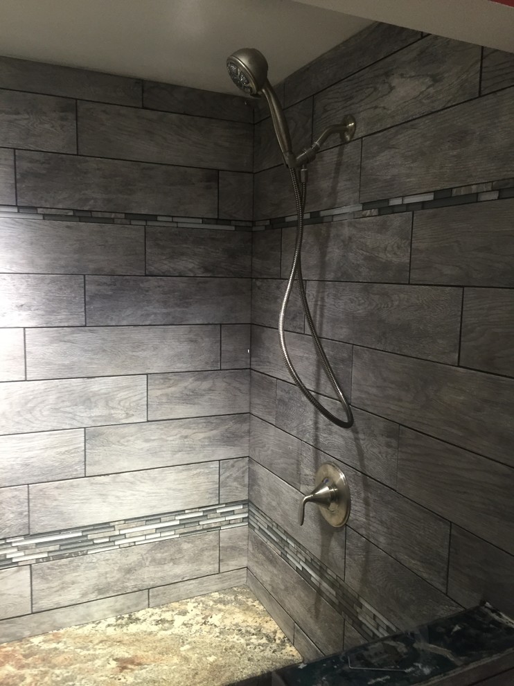 This is an example of a mid-sized contemporary 3/4 bathroom in Cleveland with an alcove shower, gray tile, porcelain tile and orange walls.
