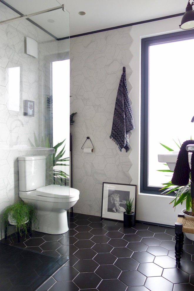 Design ideas for a small contemporary 3/4 bathroom in Other with an open shower, a two-piece toilet, white tile, ceramic tile, white walls, ceramic floors, a wall-mount sink, black floor and an open shower.
