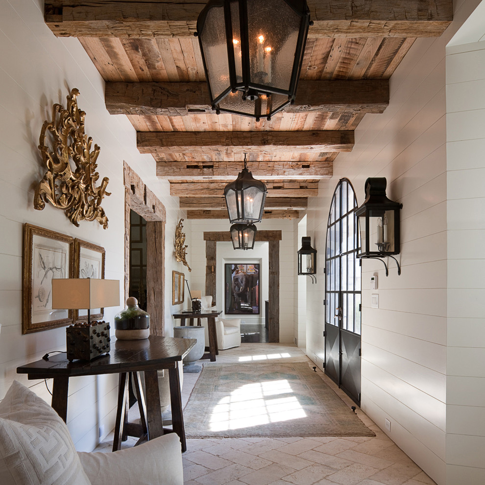 This is an example of a large mediterranean hallway in Atlanta with white walls, limestone floors and beige floor.