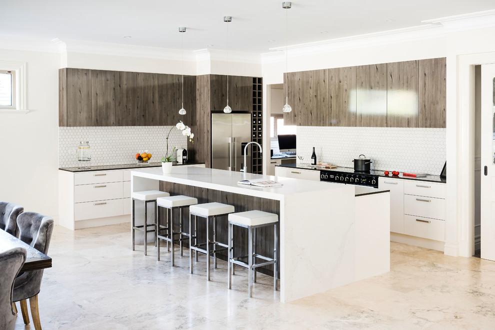 Design ideas for an expansive contemporary l-shaped open plan kitchen in Melbourne with an undermount sink, flat-panel cabinets, light wood cabinets, quartz benchtops, white splashback, mosaic tile splashback, black appliances, marble floors, with island and pink floor.