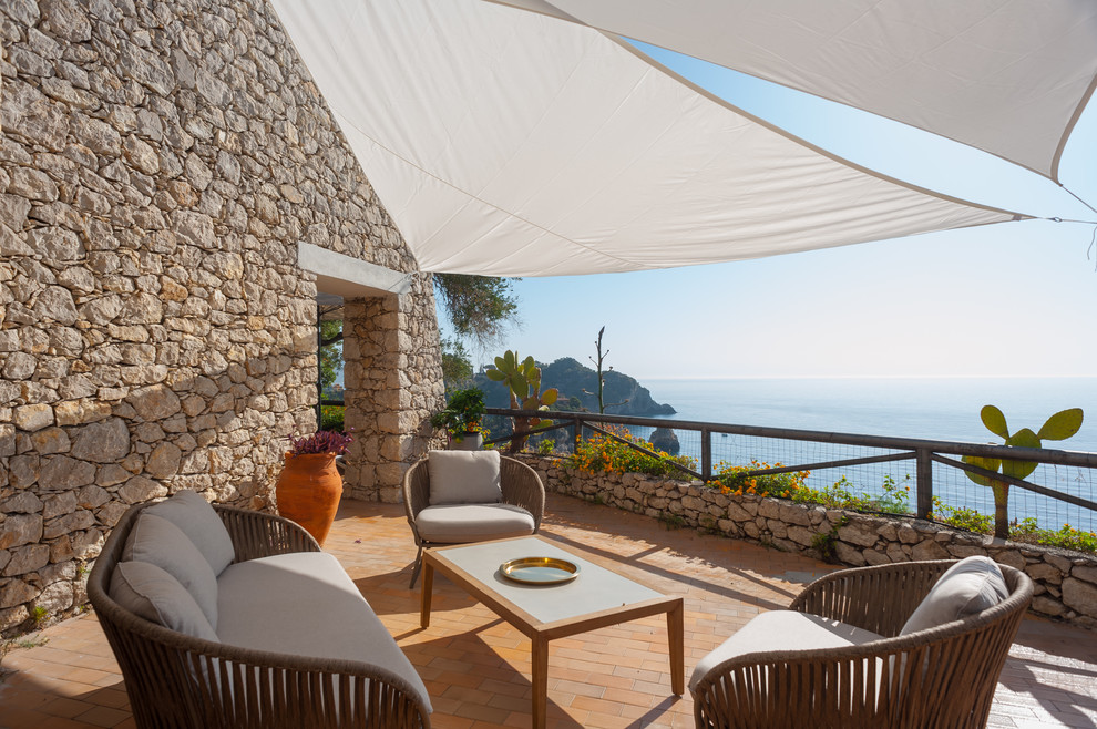 This is an example of a mediterranean balcony in Other with an awning.