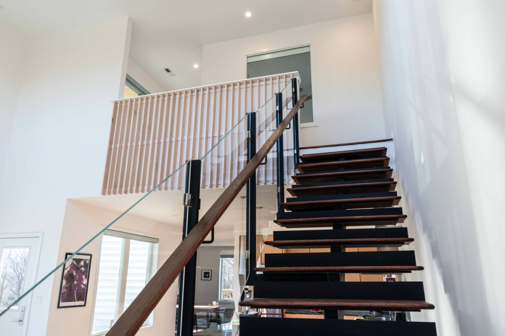Photo of a contemporary glass floating staircase in Chicago with metal risers and wood railing.