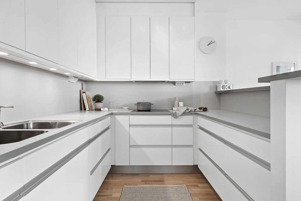 Design ideas for a scandinavian u-shaped kitchen in Copenhagen with white cabinets and no island.