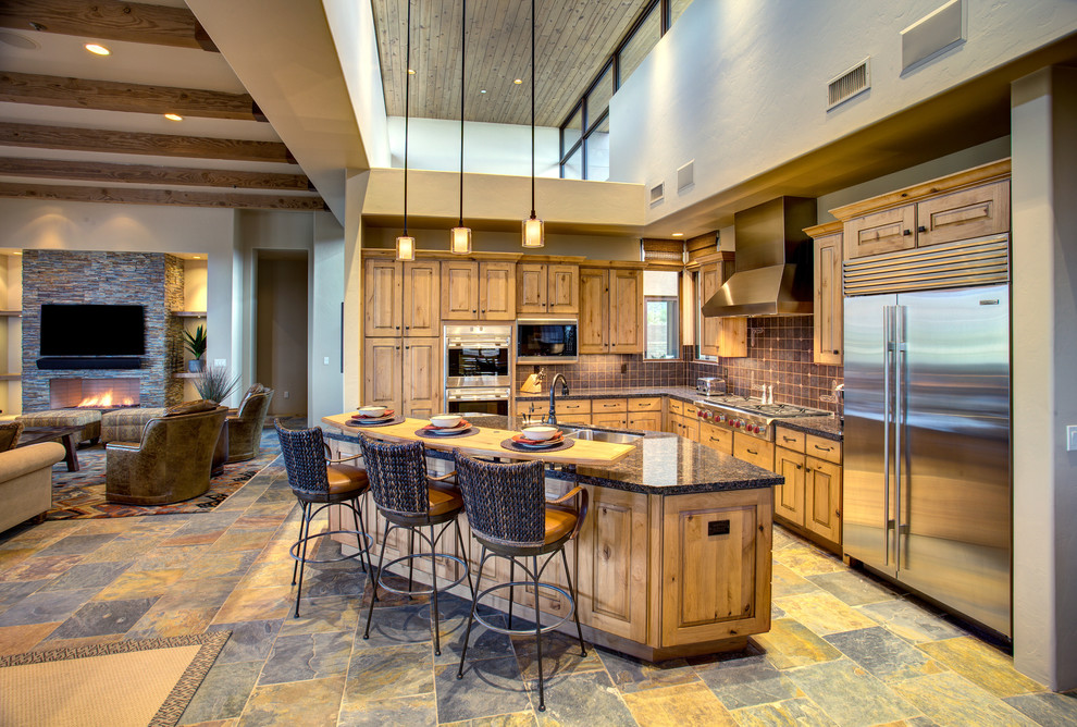 Large l-shaped open plan kitchen in Phoenix with a double-bowl sink, raised-panel cabinets, medium wood cabinets, granite benchtops, stainless steel appliances, slate floors, with island and multi-coloured floor.