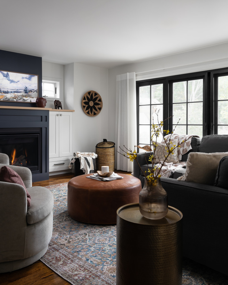 Пример оригинального дизайна: открытая гостиная комната среднего размера в стиле модернизм с белыми стенами, паркетным полом среднего тона, стандартным камином, фасадом камина из дерева и телевизором на стене