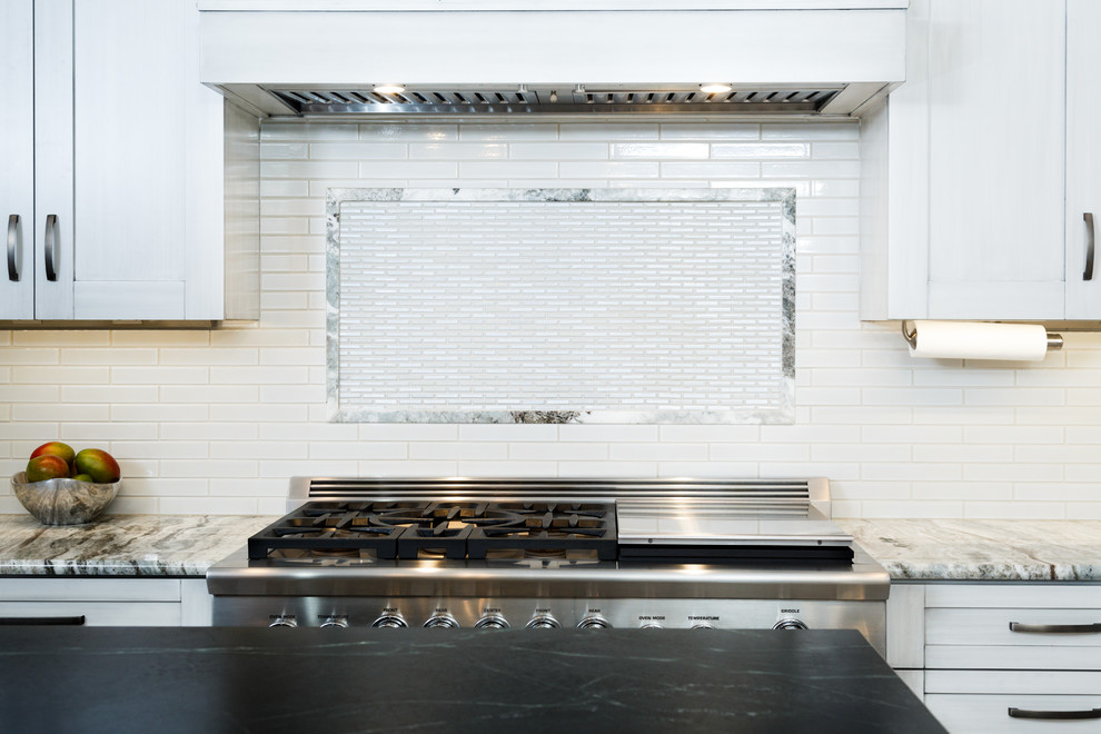 Example of a large transitional l-shaped porcelain tile eat-in kitchen design in Austin with a single-bowl sink, shaker cabinets, gray cabinets, soapstone countertops, white backsplash, ceramic backsplash, stainless steel appliances and an island