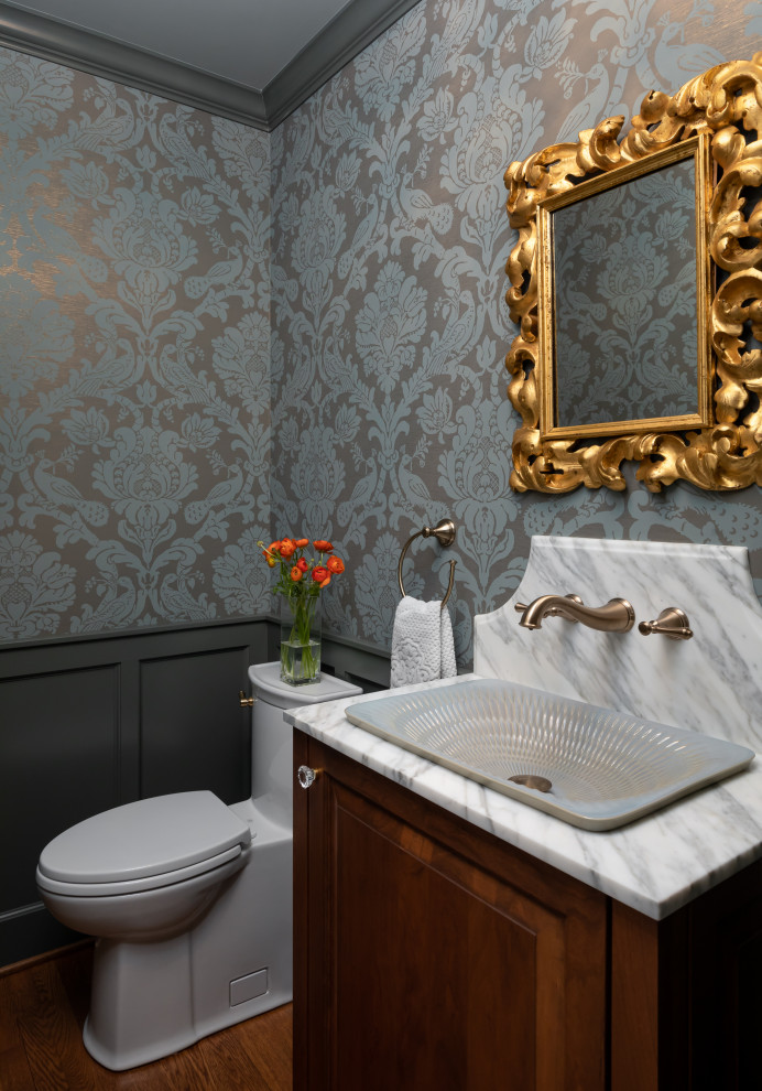 Exempel på ett litet klassiskt vit vitt toalett, med möbel-liknande, skåp i mellenmörkt trä, en toalettstol med hel cisternkåpa, grå väggar, mellanmörkt trägolv, ett fristående handfat och marmorbänkskiva