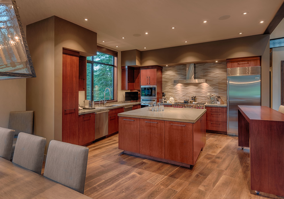 Inspiration for a contemporary l-shaped eat-in kitchen in Sacramento with flat-panel cabinets, dark wood cabinets, beige splashback and stainless steel appliances.