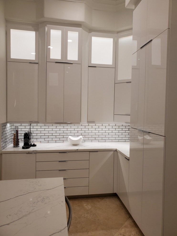 This is an example of a large modern u-shaped eat-in kitchen in Miami with white cabinets, quartz benchtops and with island.