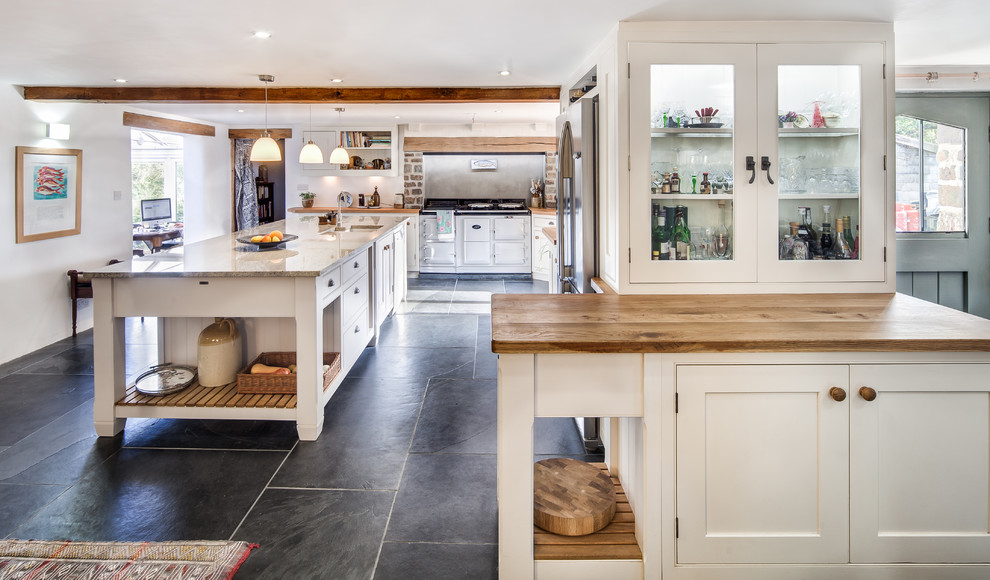 Inspiration for a large country single-wall kitchen in Cornwall with an undermount sink, shaker cabinets, beige cabinets, concrete benchtops, grey splashback, ceramic splashback, stainless steel appliances, concrete floors, with island and black floor.