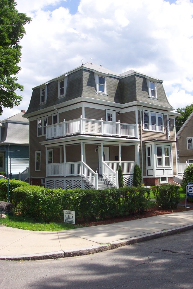 Mid-sized traditional three-storey beige house exterior in Boston with wood siding and a gambrel roof.
