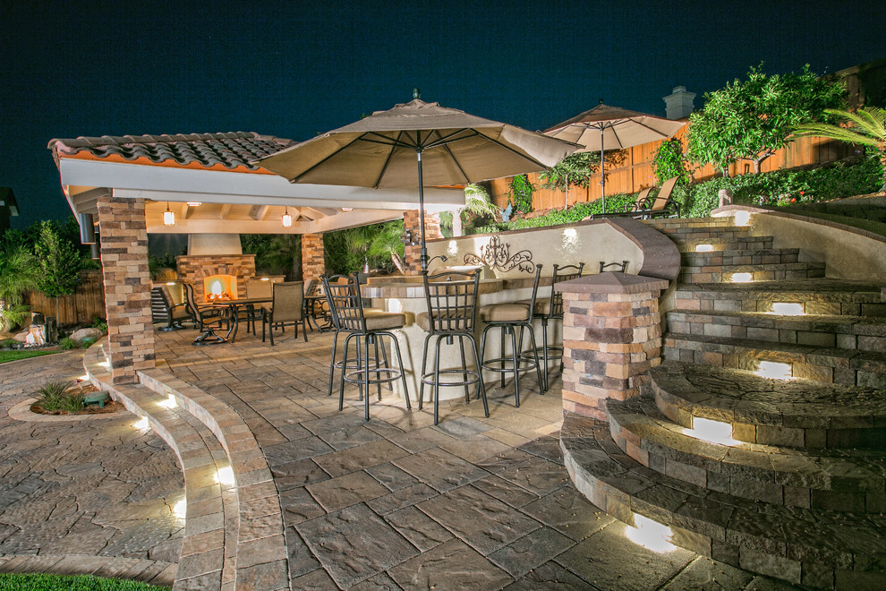 This is an example of a mid-sized traditional backyard patio in San Diego with an outdoor kitchen, concrete pavers and a gazebo/cabana.