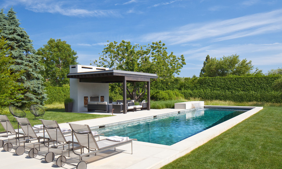 Contemporary backyard pool in New York with a water feature.