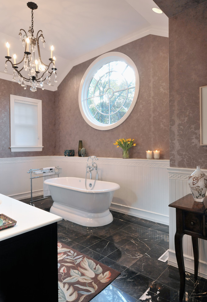 Mid-sized transitional master bathroom in New York with brown cabinets, a freestanding tub, beige walls, marble floors, an undermount sink, solid surface benchtops and black floor.