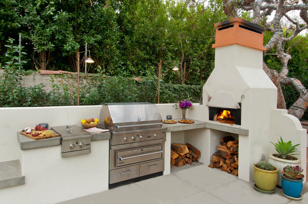 Photo of a mediterranean backyard patio in Los Angeles with concrete pavers and no cover.
