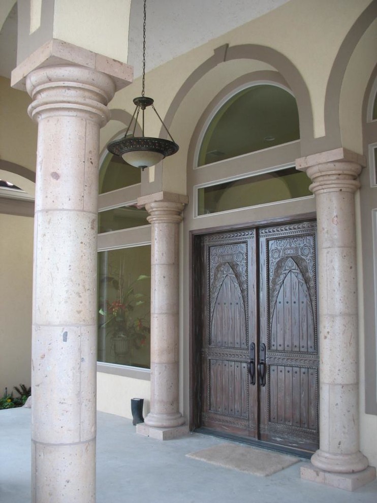 Large concrete floor front door photo with beige walls and a dark wood front door