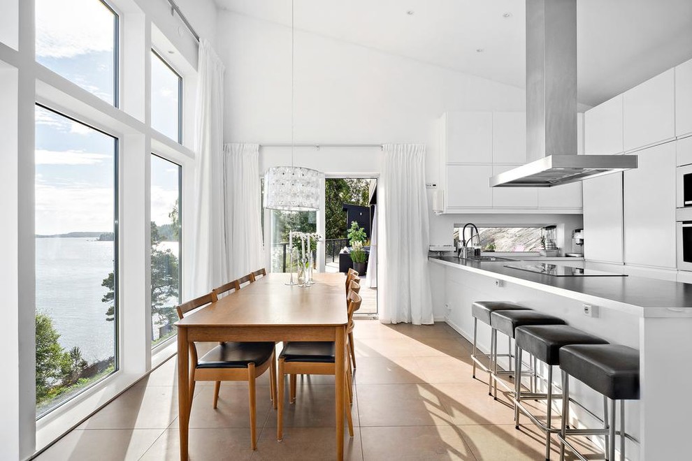 This is an example of an expansive scandinavian kitchen/dining combo in Stockholm with white walls.
