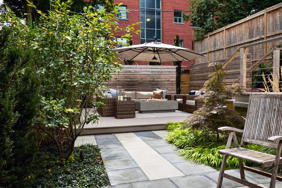 Inspiration for a mid-sized contemporary backyard patio in Toronto with with fireplace, decking and an awning.