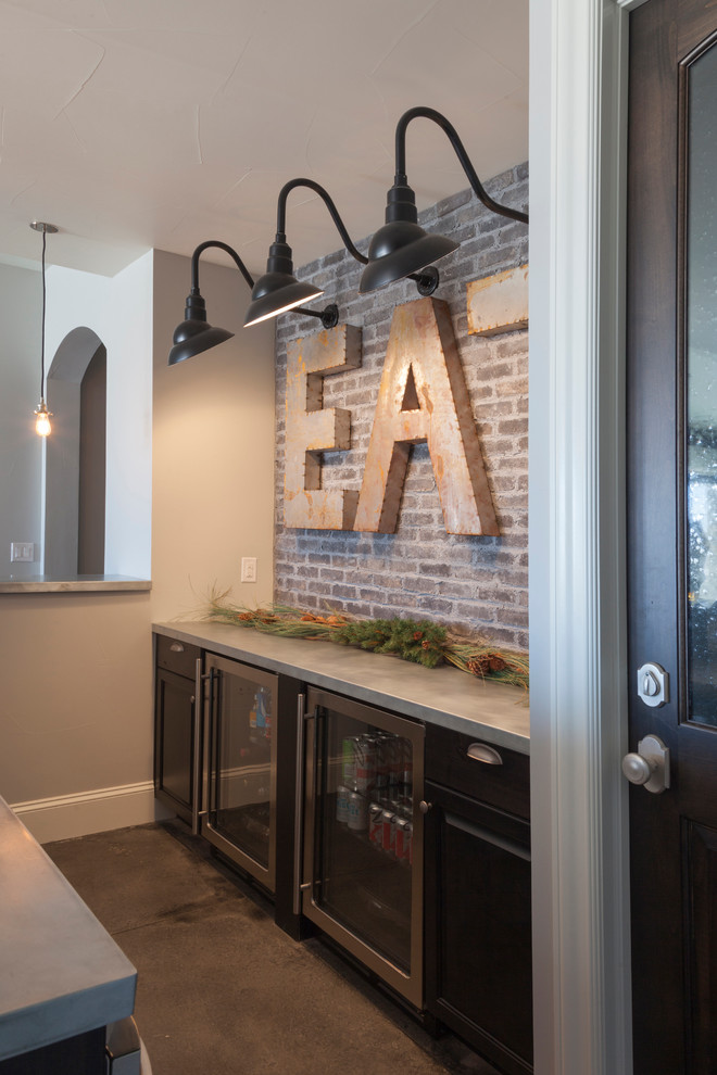 Example of a transitional medium tone wood floor home bar design in Denver with raised-panel cabinets, stainless steel appliances, an island and dark wood cabinets