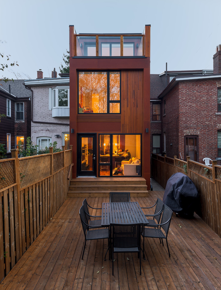 Contemporary three-storey house exterior in Toronto with wood siding.