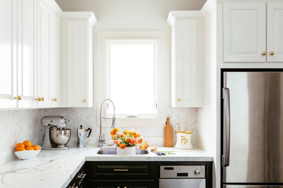 This is an example of a small transitional l-shaped eat-in kitchen in San Francisco with an undermount sink, raised-panel cabinets, white cabinets, marble benchtops, white splashback, stone tile splashback, stainless steel appliances, dark hardwood floors and no island.