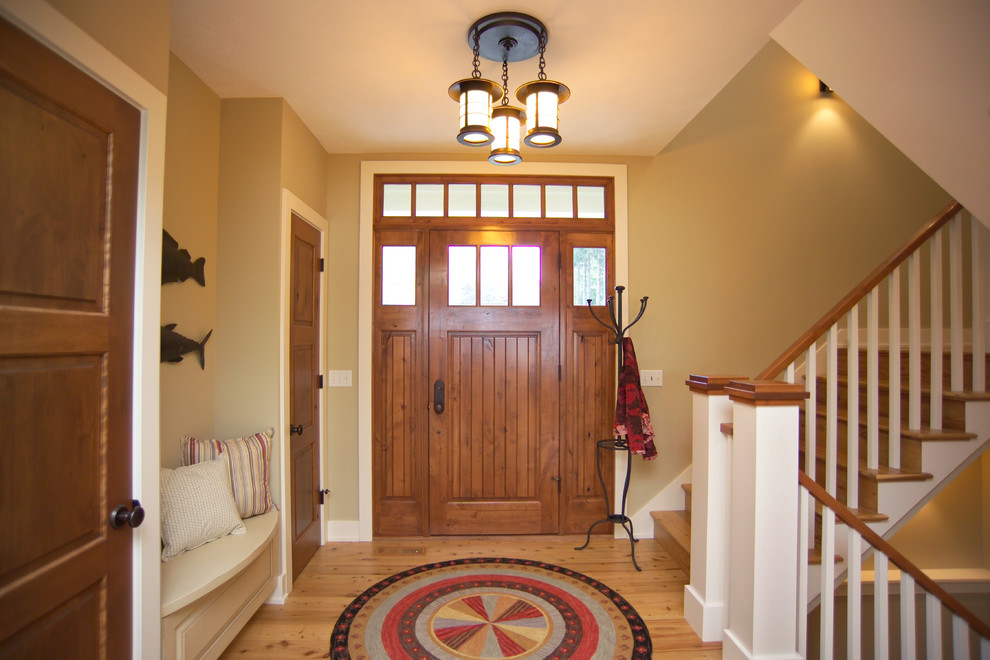 Photo of a large transitional foyer in Grand Rapids with green walls, light hardwood floors, a single front door and a medium wood front door.