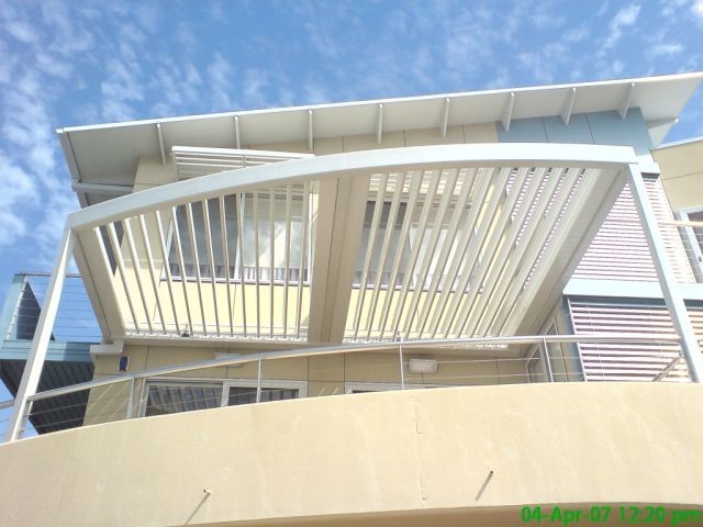 Inspiration for a mid-sized modern front yard patio in Melbourne with tile and a roof extension.