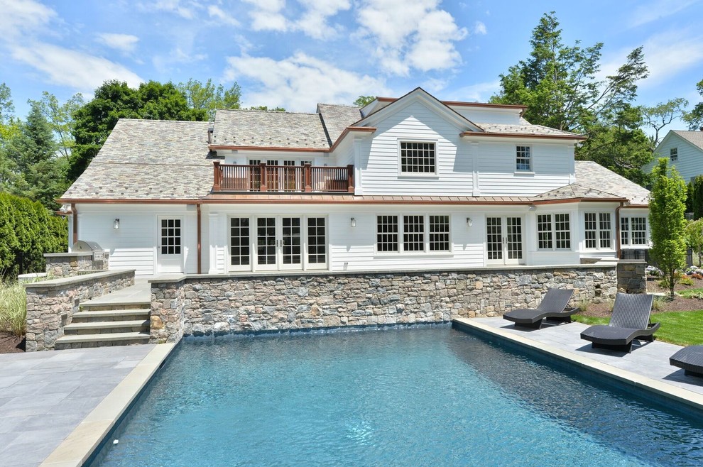 Large transitional backyard stone and rectangular lap hot tub photo in New York