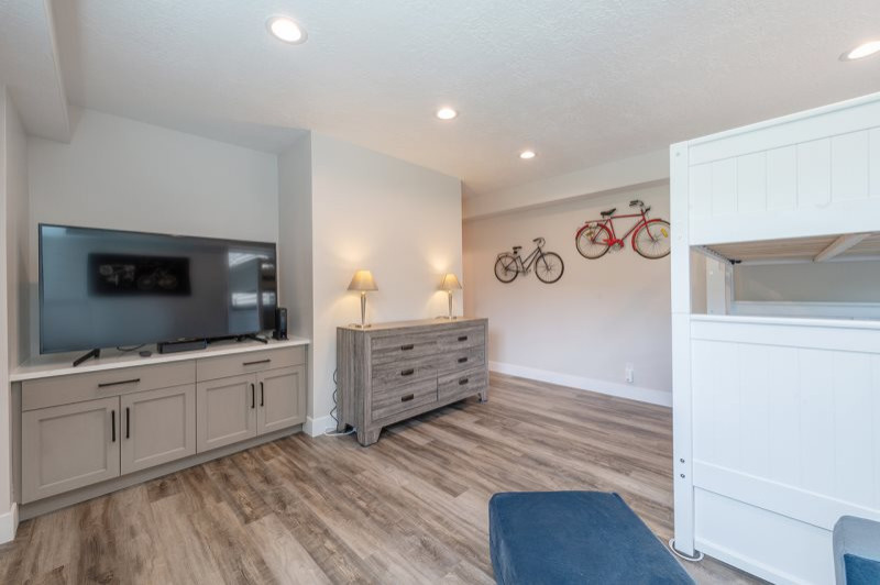 Bild på ett mellanstort minimalistiskt könsneutralt tonårsrum kombinerat med sovrum, med beige väggar, laminatgolv och flerfärgat golv