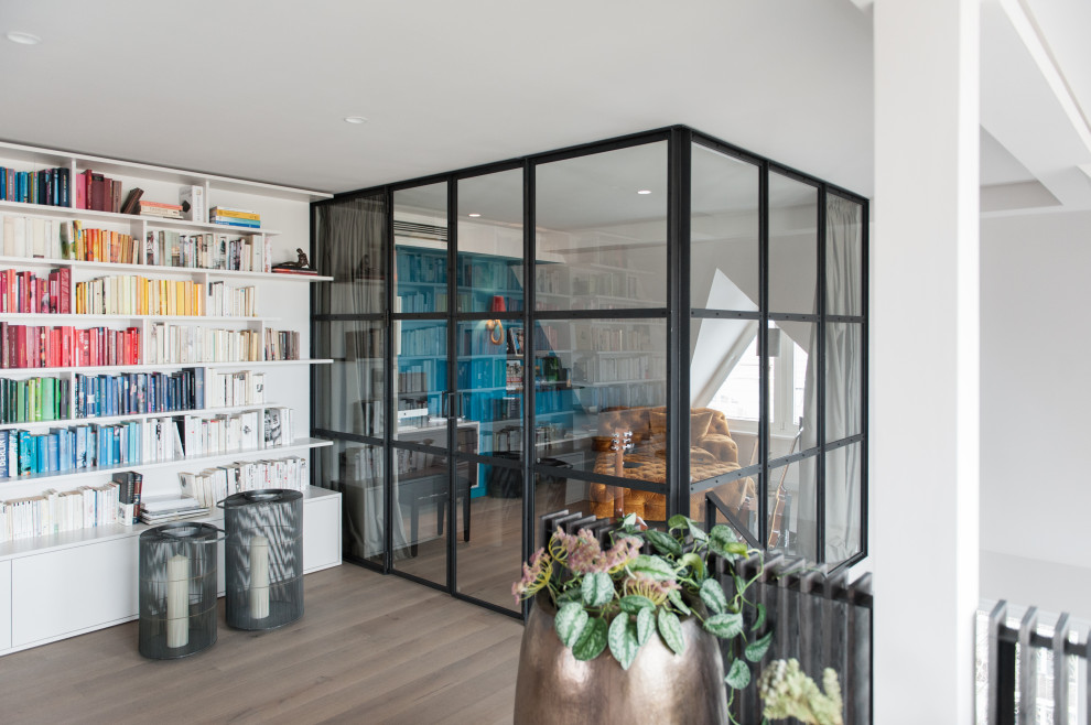 Großes Modernes Lesezimmer mit weißer Wandfarbe, Laminat und braunem Boden in Berlin