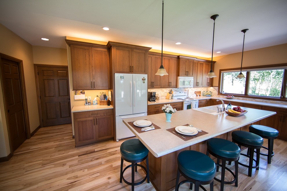 Eat-in kitchen - large transitional l-shaped light wood floor eat-in kitchen idea in Cedar Rapids with a double-bowl sink, recessed-panel cabinets, medium tone wood cabinets, laminate countertops, multicolored backsplash, mosaic tile backsplash, white appliances and an island