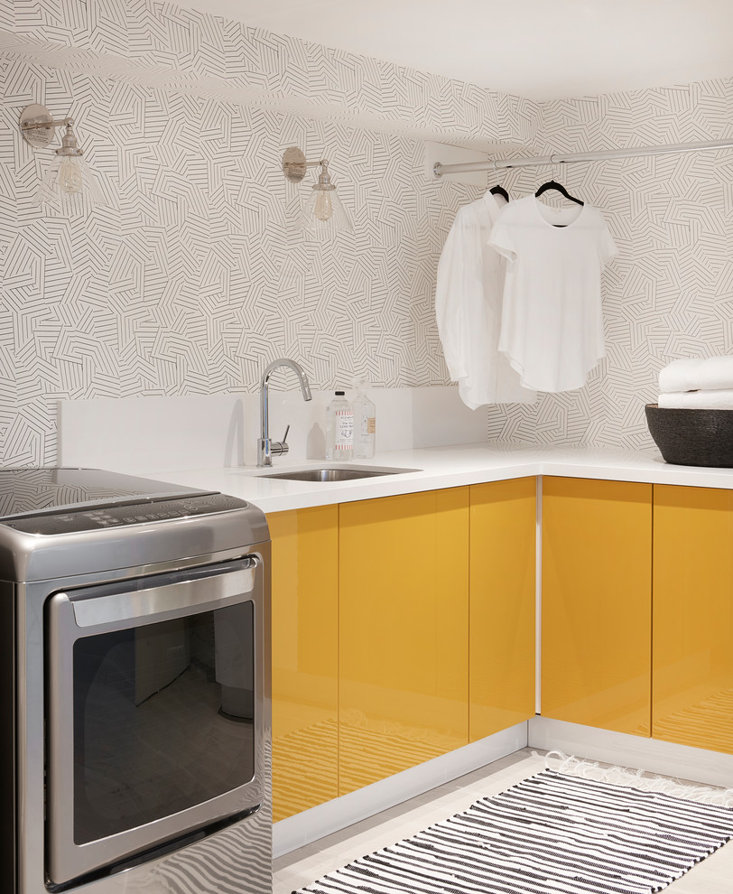 This is an example of a contemporary l-shaped laundry room in Toronto with an undermount sink, flat-panel cabinets, yellow cabinets and a side-by-side washer and dryer.