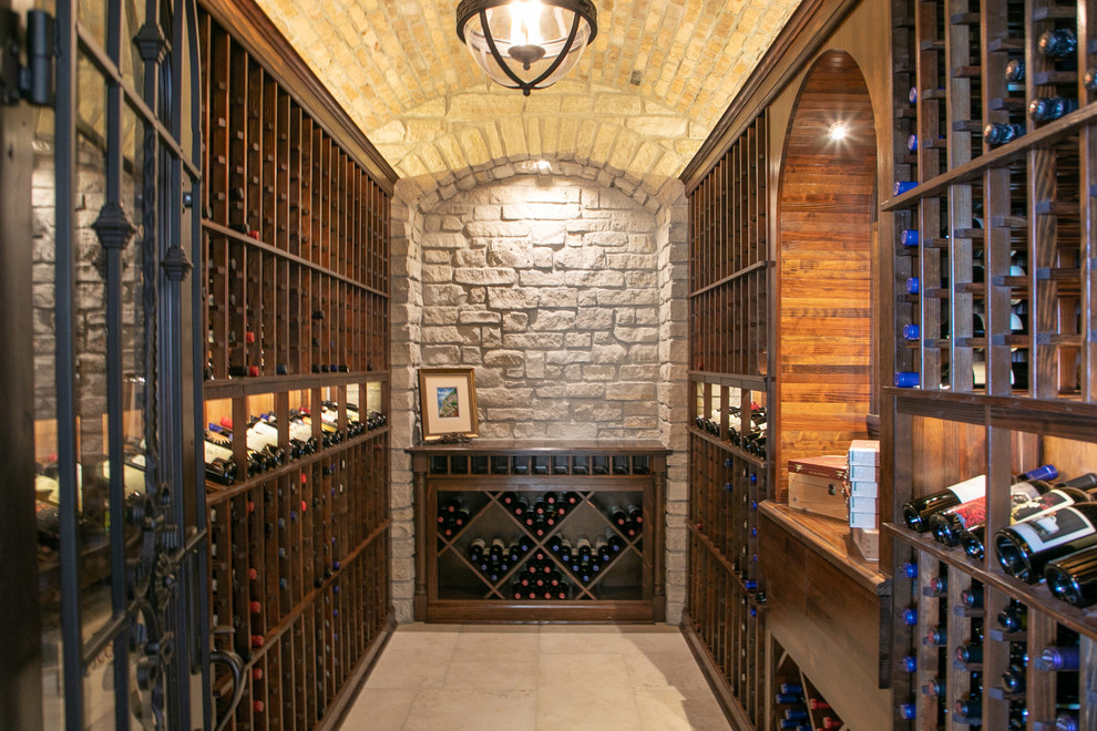 Inspiration for a large beach style wine cellar in Milwaukee with limestone floors, diamond bins and beige floor.