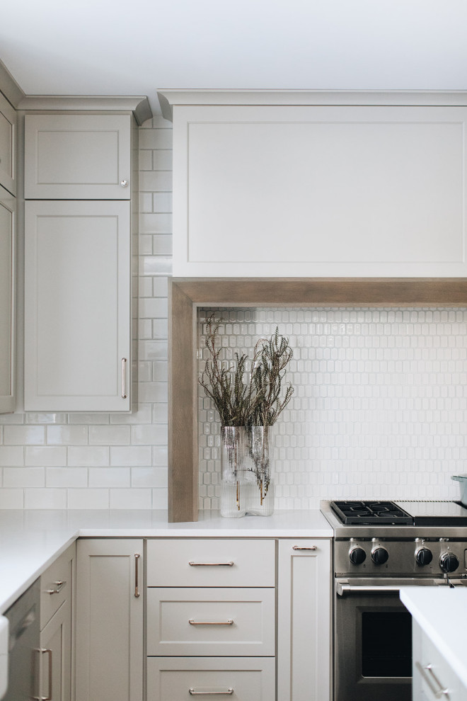Inspiration for a mid-sized transitional dark wood floor eat-in kitchen remodel in Chicago with a farmhouse sink, shaker cabinets, gray cabinets, quartz countertops, white backsplash, ceramic backsplash, paneled appliances, an island and white countertops