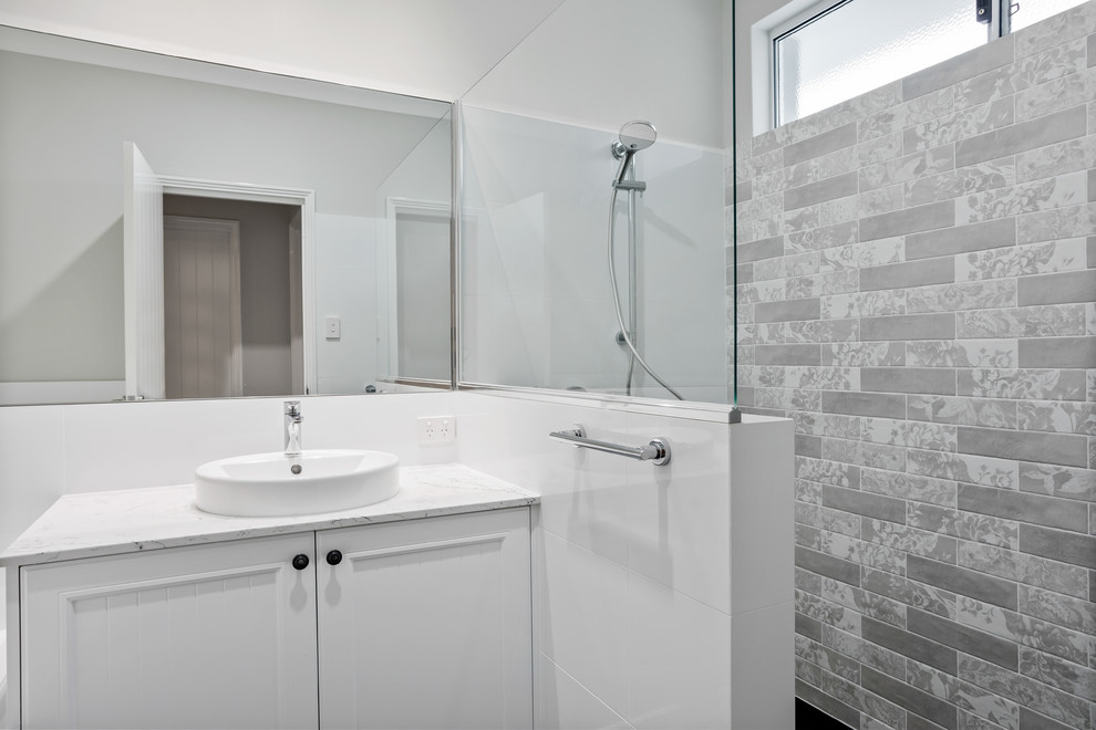 Photo of a small beach style kids bathroom in Perth with shaker cabinets, white cabinets, an open shower, white tile, porcelain tile, white walls, porcelain floors, a drop-in sink, marble benchtops, grey floor, an open shower and white benchtops.
