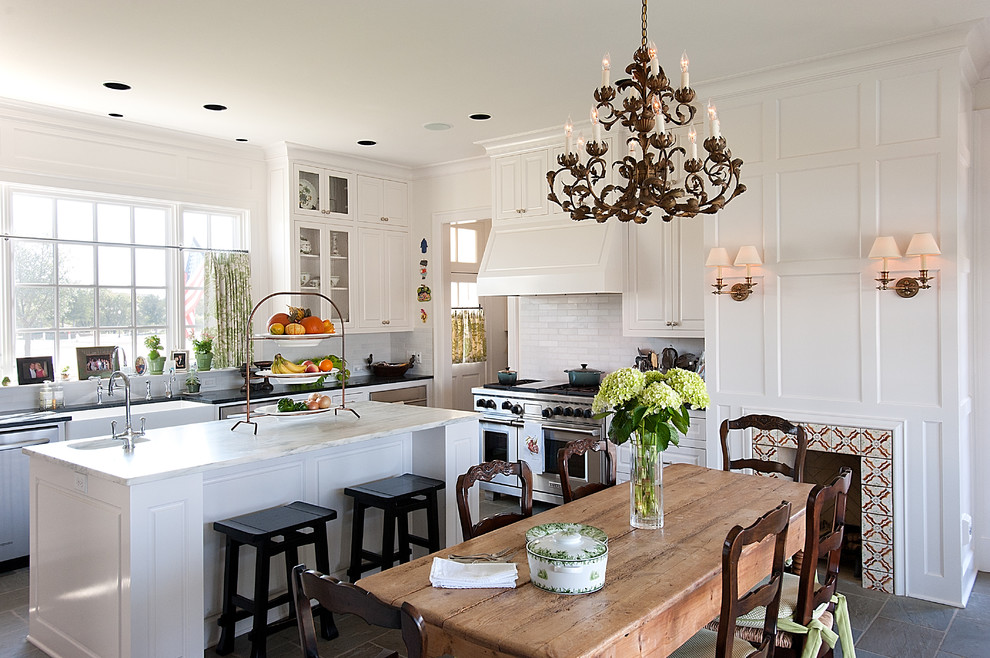 This is an example of a large traditional u-shaped separate kitchen in Dallas with subway tile splashback, a farmhouse sink, raised-panel cabinets, white cabinets, marble benchtops, white splashback and with island.