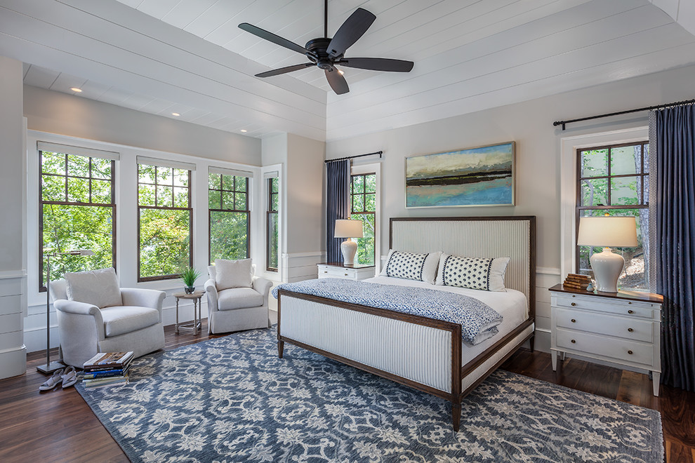 Photo of a beach style master bedroom in Other with grey walls, dark hardwood floors and brown floor.