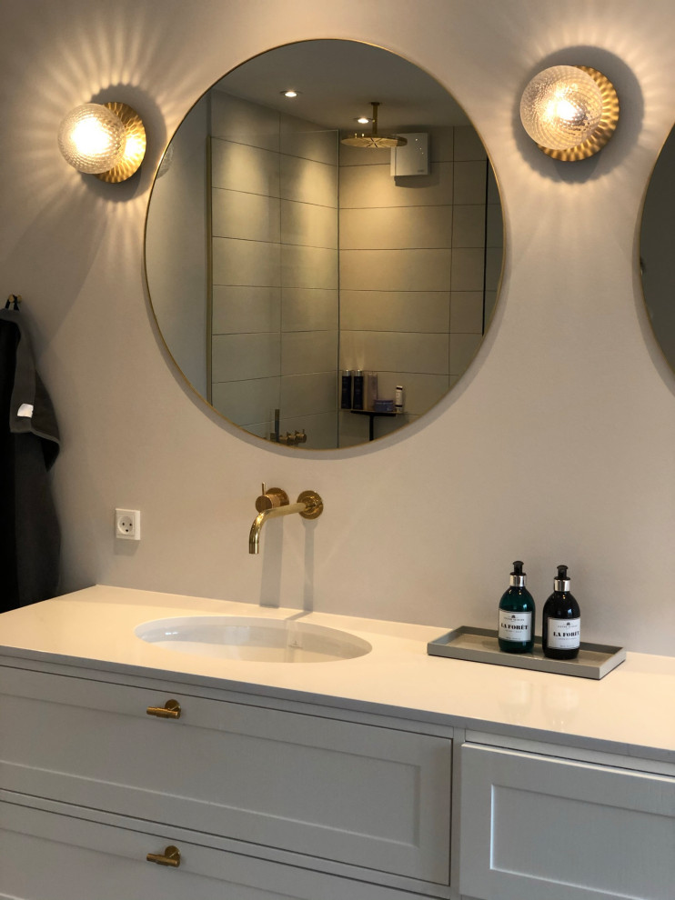 Exempel på ett stort skandinaviskt beige beige en-suite badrum, med luckor med upphöjd panel, beige skåp, ett fristående badkar, en öppen dusch, en vägghängd toalettstol, beige kakel, keramikplattor, grå väggar, klinkergolv i keramik, ett integrerad handfat, marmorbänkskiva, grått golv och med dusch som är öppen