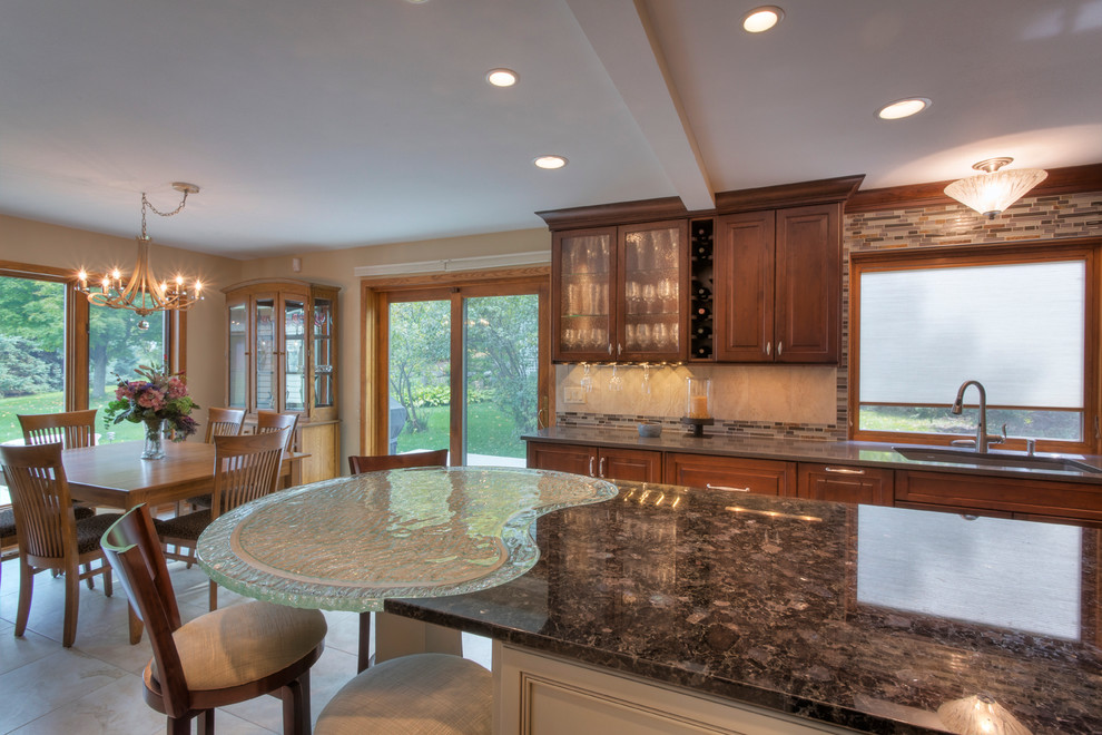 Inspiration for a large transitional l-shaped ceramic tile eat-in kitchen remodel with an undermount sink, raised-panel cabinets, medium tone wood cabinets, glass countertops, multicolored backsplash, mosaic tile backsplash, paneled appliances and an island