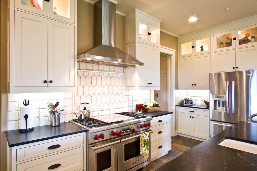 This is an example of a large arts and crafts u-shaped eat-in kitchen in Dallas with a drop-in sink, shaker cabinets, white cabinets, granite benchtops, white splashback, ceramic splashback, stainless steel appliances, ceramic floors and with island.