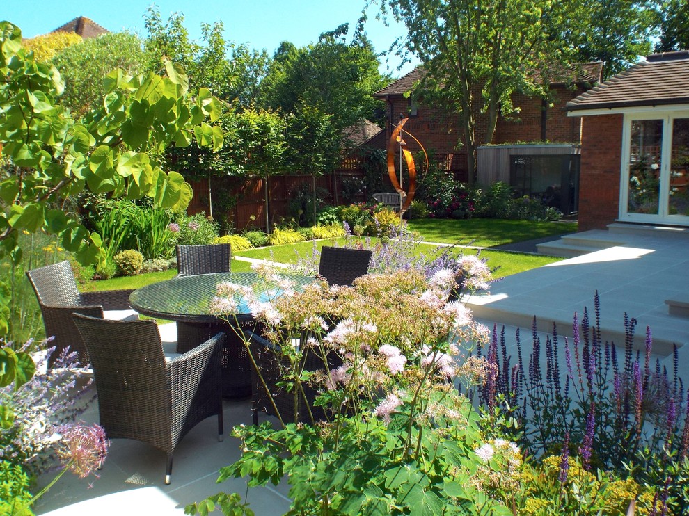 Photo of a contemporary backyard patio in Essex with natural stone pavers.