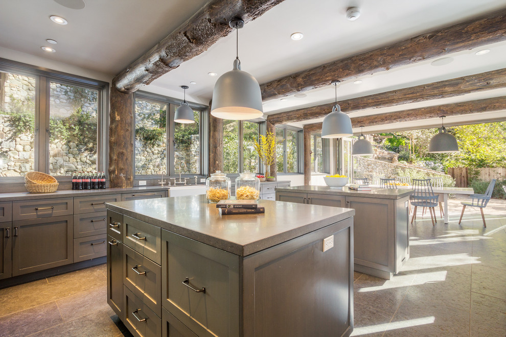 Photo of a country eat-in kitchen in Los Angeles with a farmhouse sink, shaker cabinets, grey cabinets, window splashback and multiple islands.