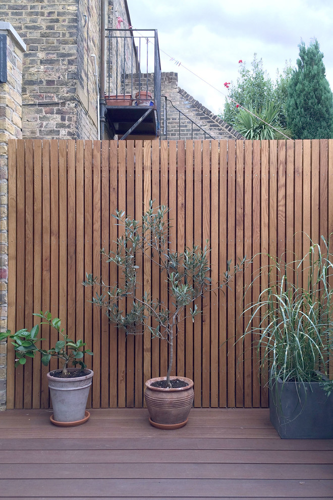 Design ideas for a small contemporary backyard patio in London with decking and no cover.